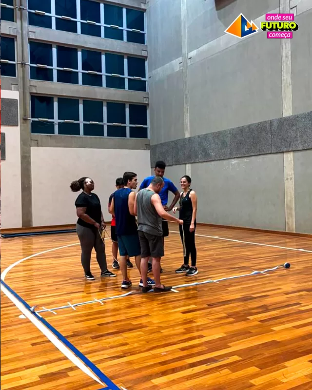 Alunos da UNIFAFIBE-7 em atividade esportiva. Grupo reunido na quadra, piso de madeira. UNIFAFIBE incentivando o esporte e futuro.